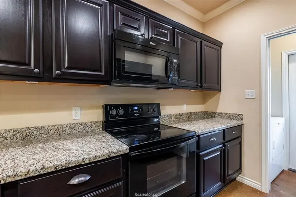 a kitchen with stainless steel appliances granite countertop a stove microwave and sink