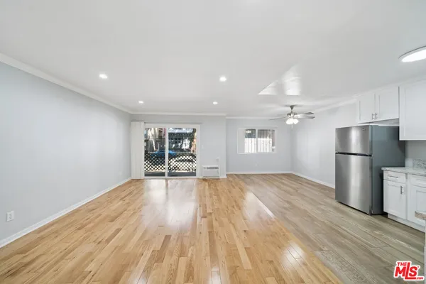 a view of an empty room with a window and wooden floor
