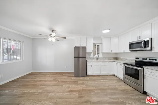 a kitchen with granite countertop a stove top oven and refrigerator