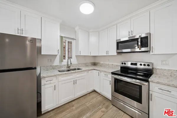 a kitchen with stainless steel appliances a stove microwave and sink