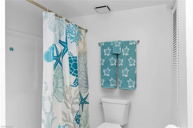 a bathroom with a potted plant and a shower curtain