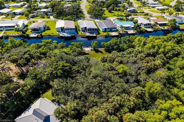 an aerial view of residential houses with outdoor space and trees