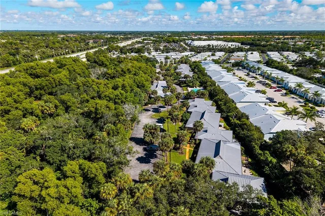 an aerial view of residential house with parking and yard