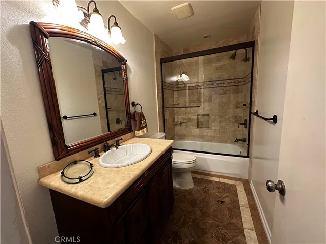 a bathroom with a granite countertop sink a mirror and a shower