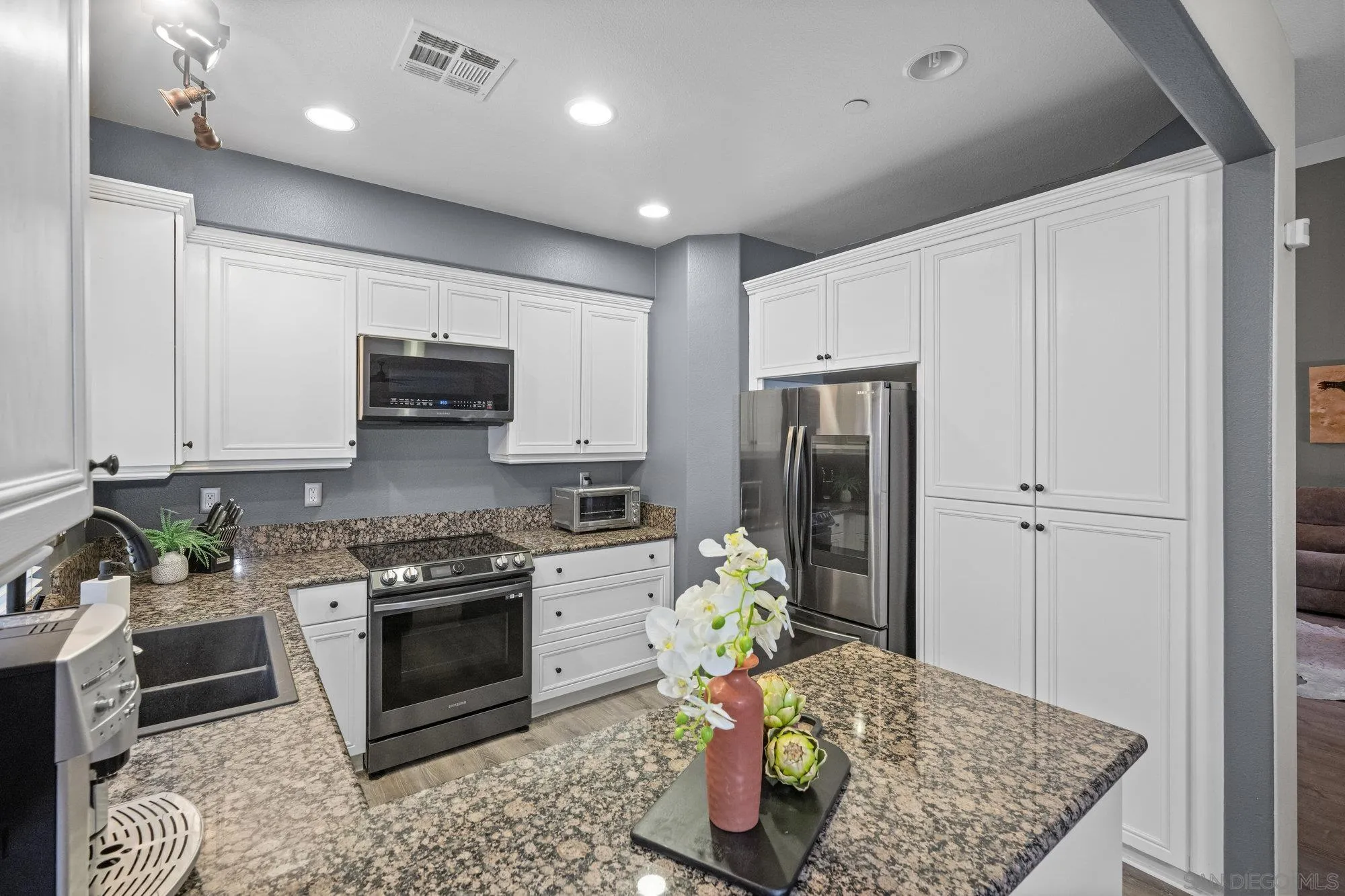 640 Dimaio Way Escondido, CA 92027 - Photo 11 of 31 a kitchen with stainless steel appliances granite countertop a stove top oven a sink and cabinets