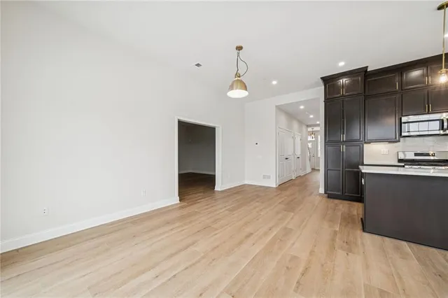 a view of kitchen with refrigerator microwave and stove