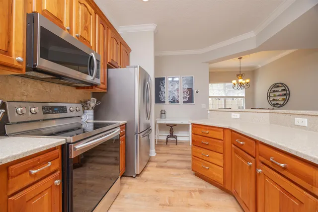 a kitchen with stainless steel appliances granite countertop a refrigerator and a stove top oven