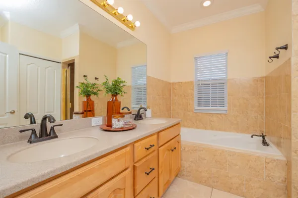 a bathroom with double vanity sinks a bathtub and a shower