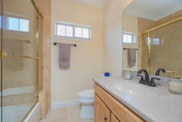 a bathroom with a granite countertop sink a toilet and shower