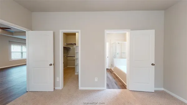 a bathroom with a tub sink shower and two mirror