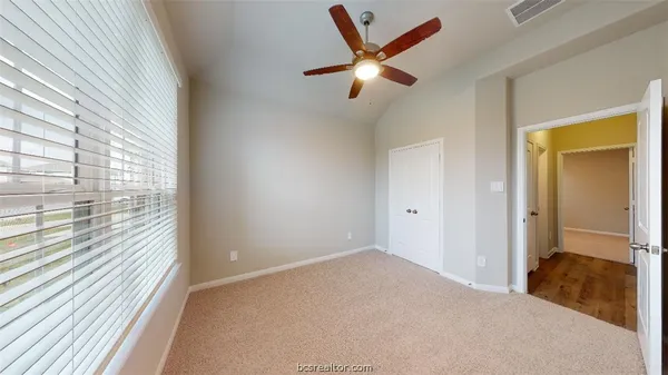 an empty room with windows and fan