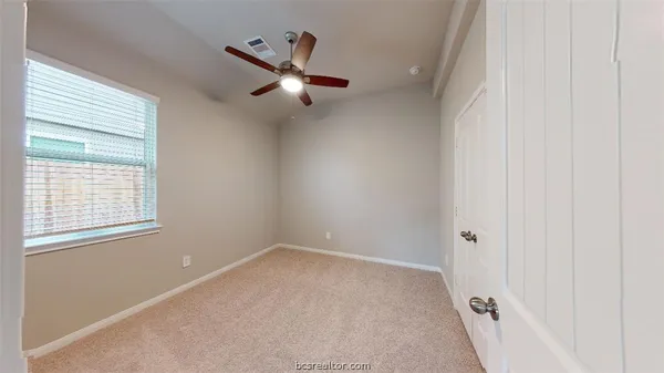 an empty room with chandelier fan