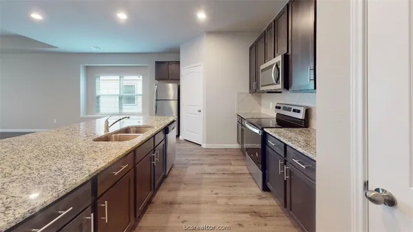 a large kitchen with stainless steel appliances granite countertop a sink and dishwasher