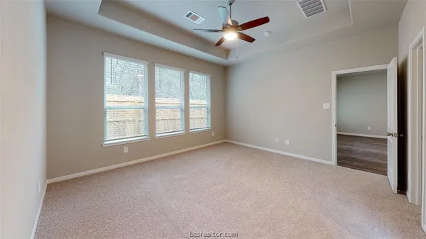 an empty room with closet and a ceiling fan