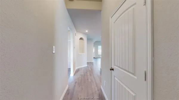a view of a hallway with wooden floor and staircase