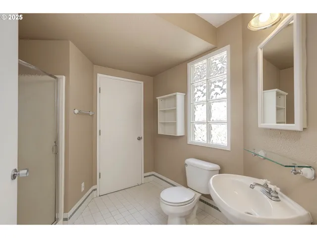 a bathroom with a toilet sink a mirror and next to a window