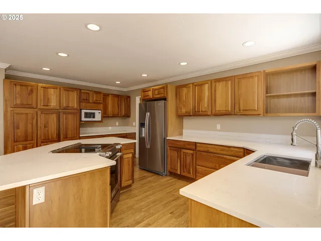 a kitchen with stainless steel appliances granite countertop a sink stove and refrigerator