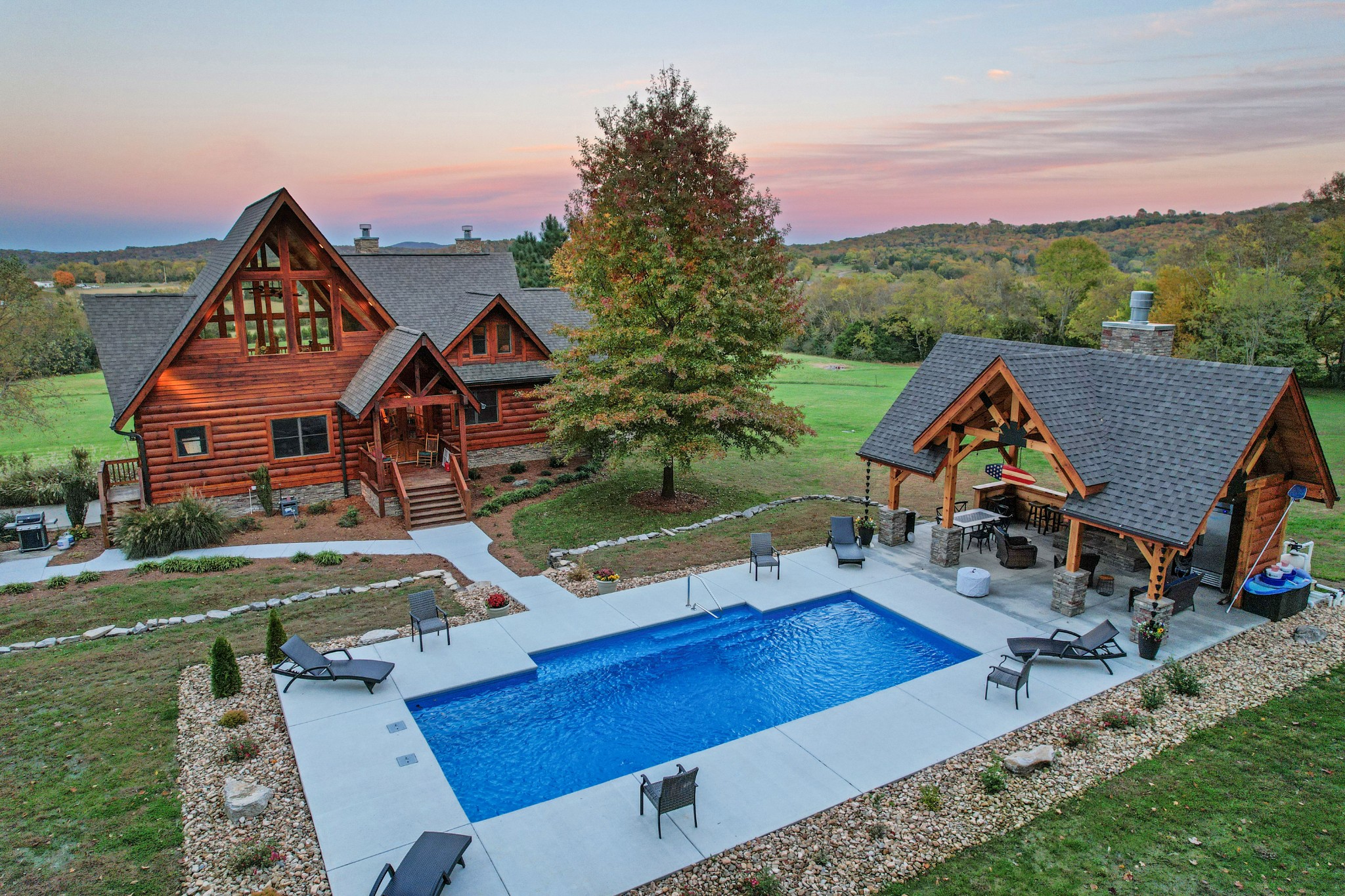 an aerial view of a house with swimming pool garden and mountain view in back