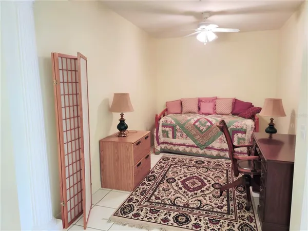 a bed sitting in a bedroom next to a lamp