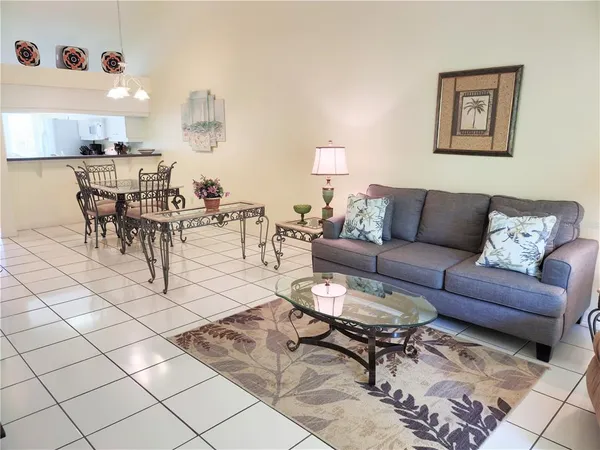 a living room with furniture and a dining table with kitchen view