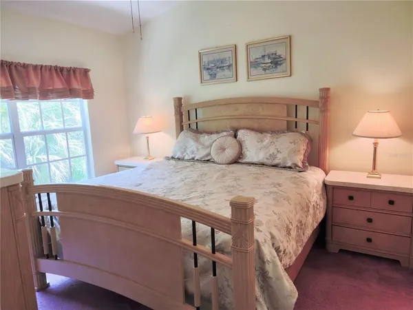 a bedroom with a bed and a lamp on dresser