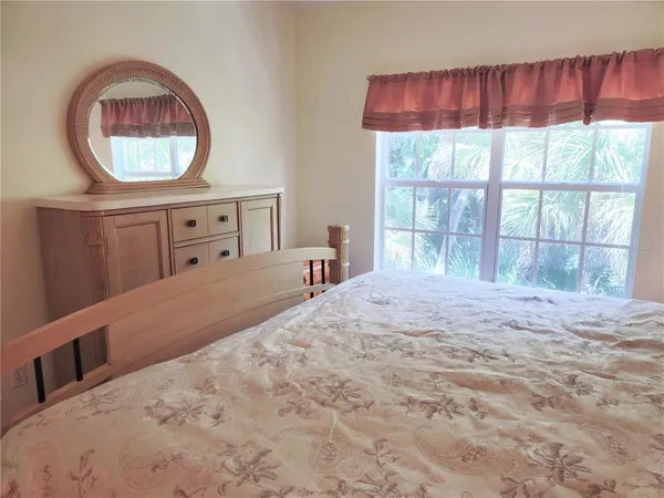 a bedroom with a bed and a large window