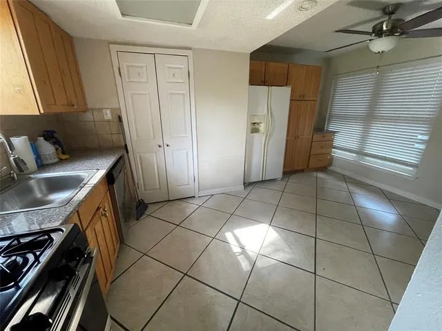 a kitchen with stainless steel appliances granite countertop a refrigerator and a stove top oven