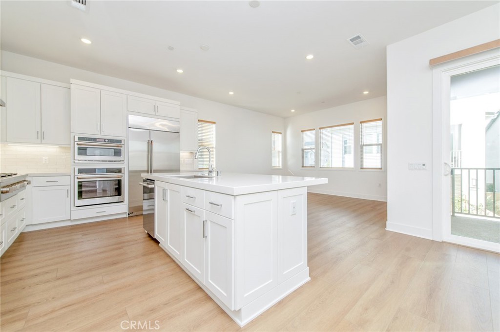 110 Seep Irvine, CA 92618 - Photo 15 of 37 a kitchen with stainless steel appliances granite countertop a stove top oven a sink dishwasher and a refrigerator with wooden floor