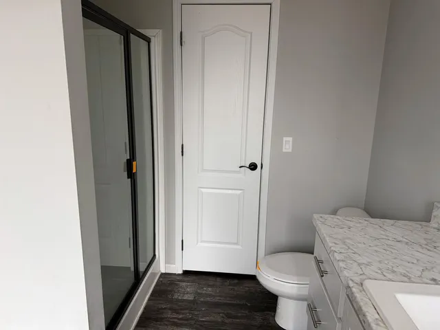 a bathroom with a toilet and a shower
