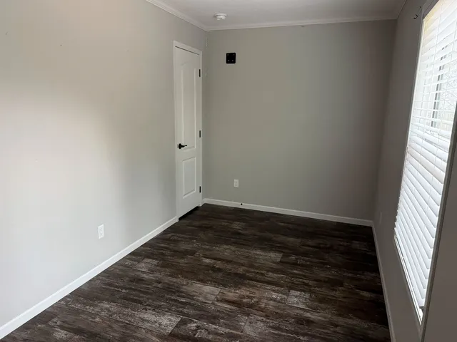 a view of a room with wooden floor and window