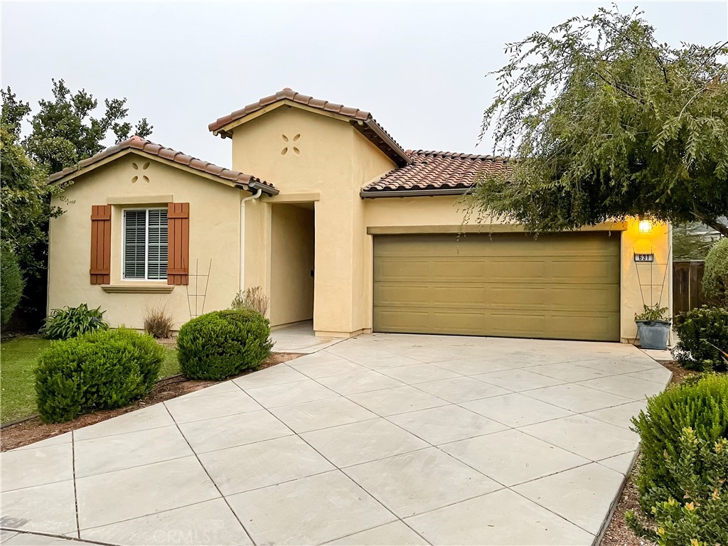 a front view of a house with a yard and trees