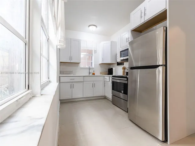 a kitchen with white cabinets and white stainless steel appliances