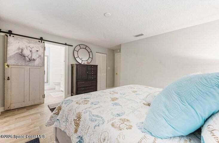 108 Washington Avenue Cape Canaveral, FL 32920 - Photo 12 of 35 a bedroom with a bed and a mirror