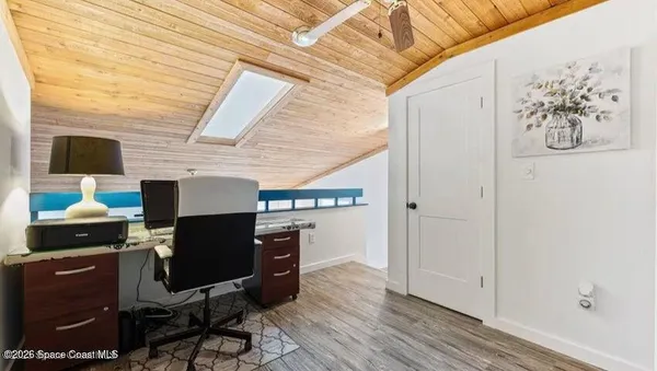 a view of a workspace with furniture and a window