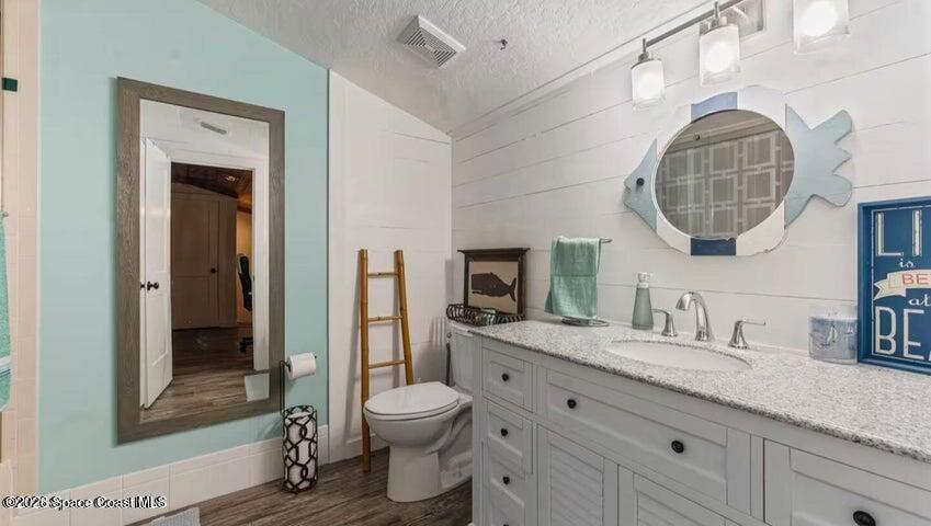 108 Washington Avenue Cape Canaveral, FL 32920 - Photo 21 of 35 a bathroom with a granite countertop sink mirror vanity and toilet