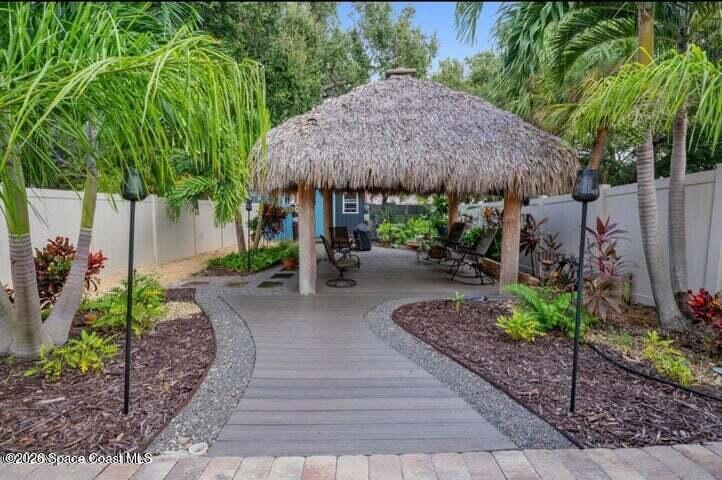 108 Washington Avenue Cape Canaveral, FL 32920 - Photo 27 of 35 a backyard of a house with a table and chairs under an umbrella