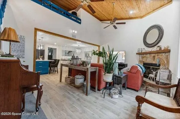 a living room with furniture a fireplace and a dining table with wooden floor