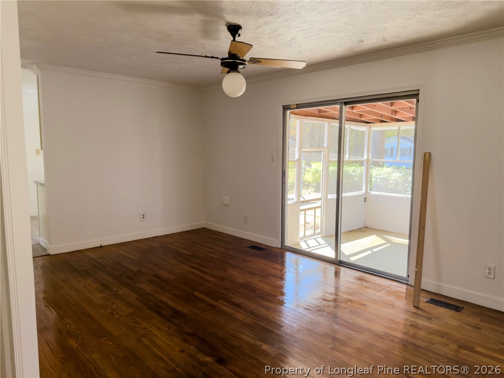 598 Forest Road Lumberton, NC 28358 - Photo 8 of 25 an empty room with wooden floor fan and windows