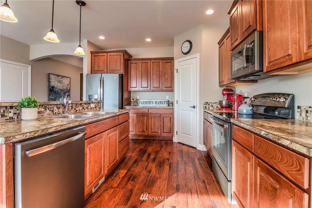 5904 Crestfields Road Yakima, WA 98903 - Photo 12 of 39 a kitchen with stainless steel appliances granite countertop a sink and wooden cabinets