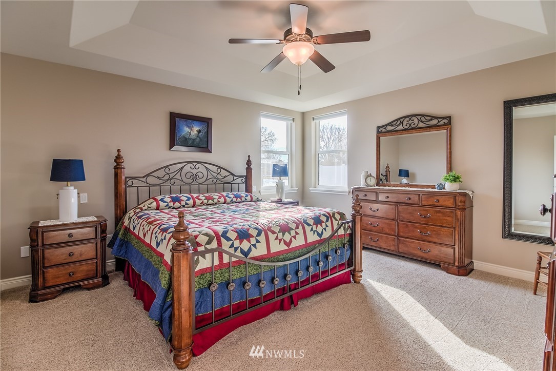 5904 Crestfields Road Yakima, WA 98903 - Photo 21 of 39 a bedroom with a bed a chandelier and dresser