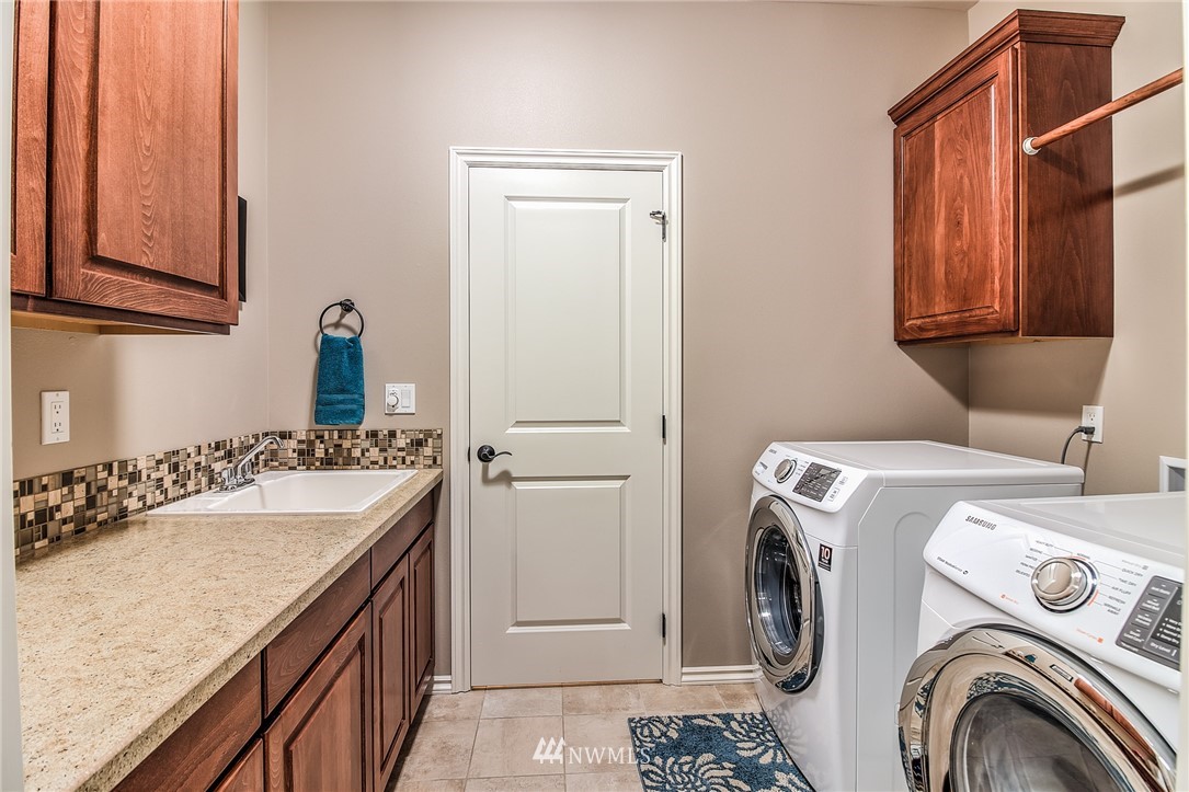 5904 Crestfields Road Yakima, WA 98903 - Photo 27 of 39 a bathroom with a sink a washer and dryer