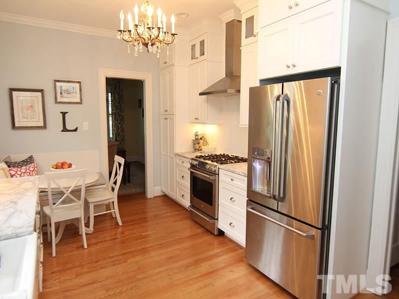 2020 St Marys Street Raleigh, NC 27608 - Photo 14 of 25 a kitchen with stainless steel appliances granite countertop a refrigerator a stove and a dining table with wooden floor