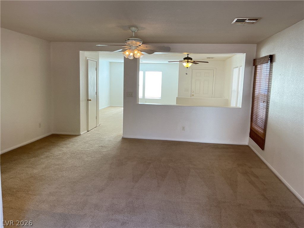 8108 Roundup Ridge Street Las Vegas, NV 89131 - Photo 7 of 21 A versatile open-concept living area boasts warm carpeting and multiple ceiling fans.