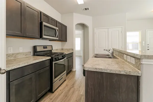 a kitchen with stainless steel appliances granite countertop a sink stove and microwave