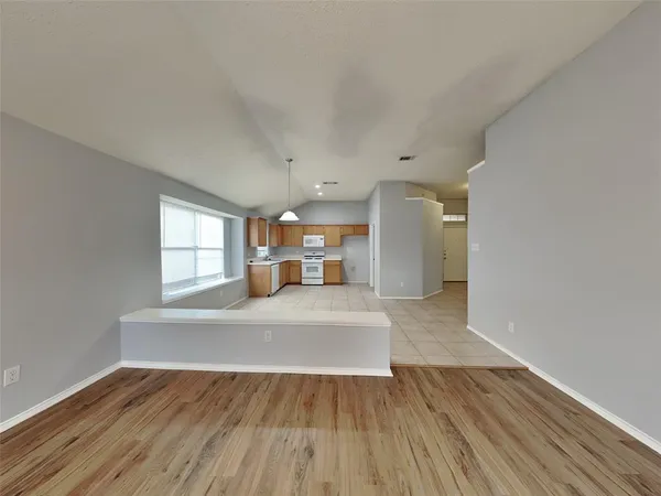 a view of a kitchen with furniture and wooden floor