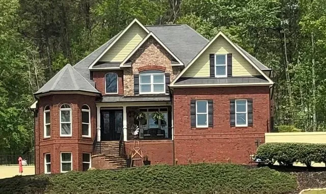 a view of a house with large windows and a yard