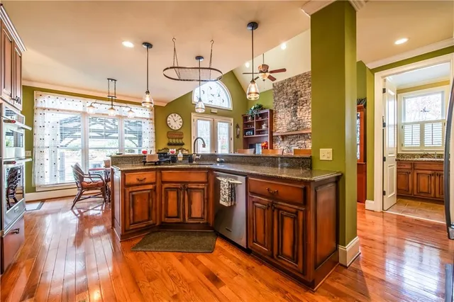 a kitchen with stainless steel appliances granite countertop a refrigerator a stove and a sink