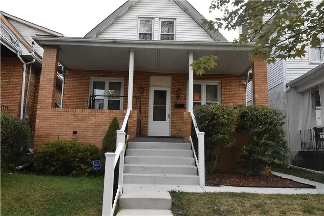 a front view of a house with plants
