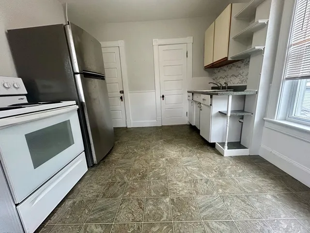 a view of kitchen with stainless steel appliances wooden floor sink and stove