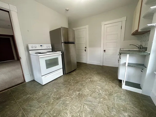 a view of kitchen with refrigerator stove sink and cabinets